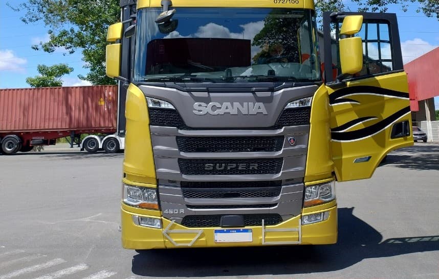 Scania 460R Super amarela da frota Covre, de frente, com a porta aberta, no pátio da matriz