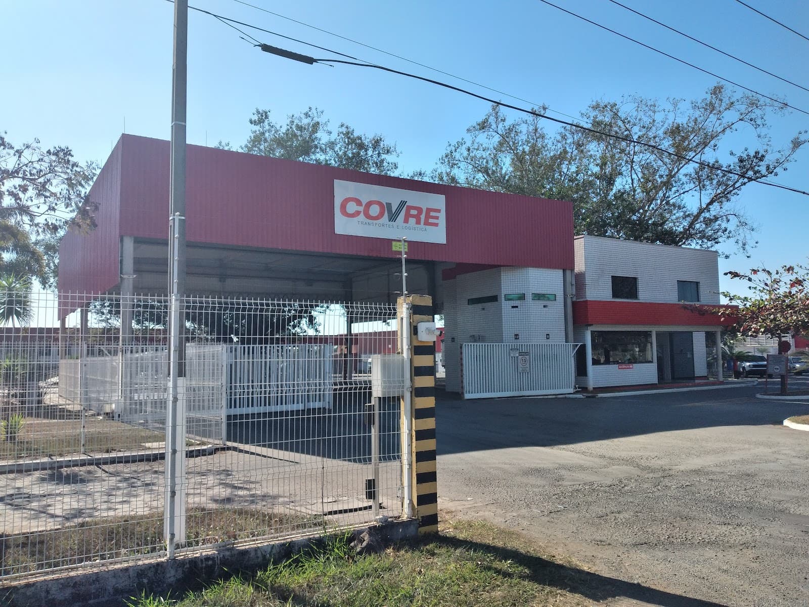 Portaria da matriz da Covre, com a cobertura vermelha do letreiro COVRE e o prédio de recepção ao lado